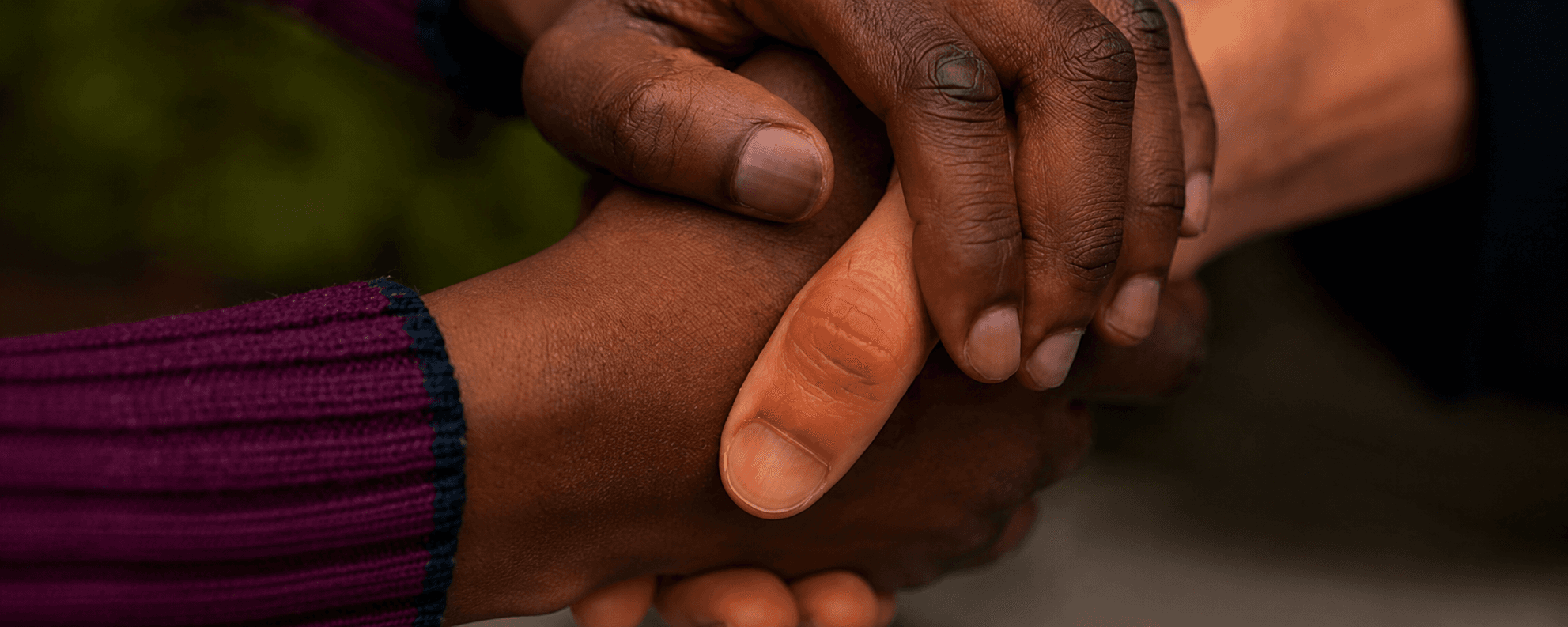 A patient and caregiver holding hands